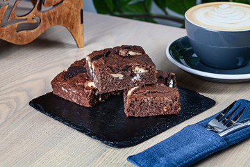 Close up view on stack of homemade brownies with coffee. Useful picture for recipe or menu. Copy space for design. Fresh bakery and dessert.