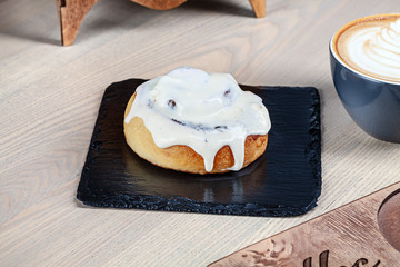 Close up view on fresh homemade  cinnabon bun with coffee. Sweet morning. Bakery with copy space. Sweet dessert for cooking book or recipe