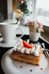 Millefeuille Napoleon with coffee in cafe. Exquisite dessert with fresh berries on white background. French Vanilla Raspberry Mille-feuille on the dish