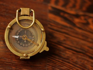 Sea compass lying on a dark wooden table