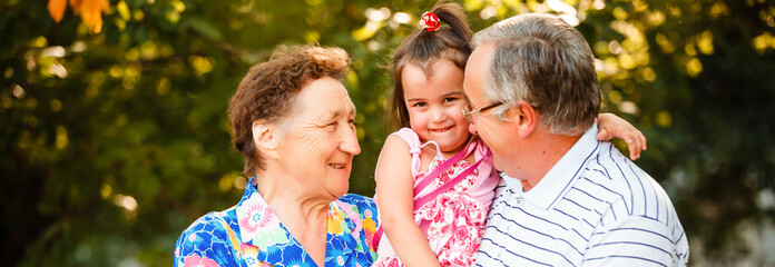 Grandparents In Park With Granddaughter