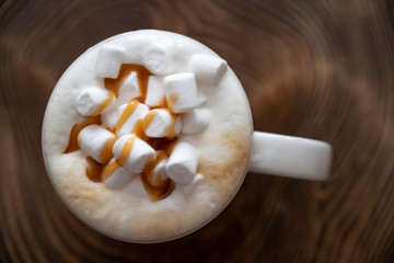 Marshmellow in coffee on a wooden surface