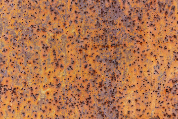 Beautiful horizontal texture of yellow and green and brown metal sheet with orange rust and holes...