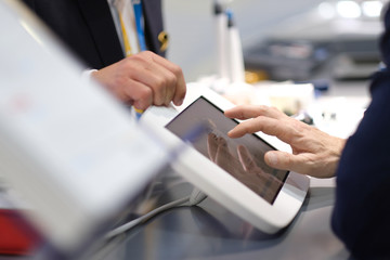 Presentation of the possibilities of medical equipment at the technology exhibition. Male hand on touchscreen