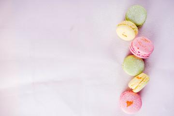Classic colorful macarons. Six pink, yellow and green macaron cookies top view copy space