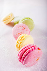 Classic colorful macarons. Six pink, yellow and green macaron cookies top view copy space