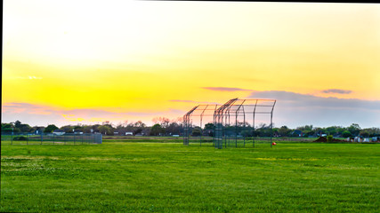 Fototapeta na wymiar A basebll backstop on a practice field in the evening.