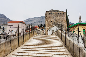 Fototapeta na wymiar View of the historic Old Bridge in Mostar, Bosnia and Herzegovina with a church tower in the background
