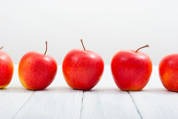 apple fruits in a row, white wooden table background