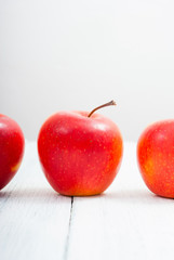 apple fruits in a row, white wooden table background