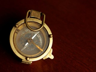 Sea compass lying on a dark wooden table