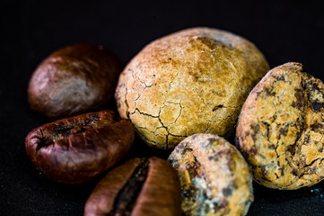 Brown roasted coffee and cocoa beans on black background, close up, macro