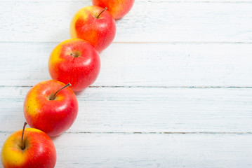 apple fruits in a row, white wooden table background