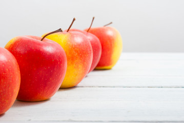 apple fruits in a row, white wooden table background