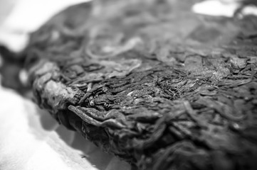 Chinese pressed puer tea on wrapping paper, close-up, macro