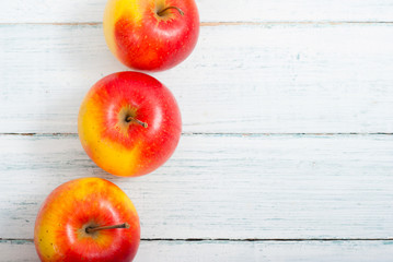 apple fruits in a row, white wooden table background