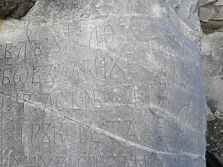 Close - up of ancient inscription carved on a large gray stone
