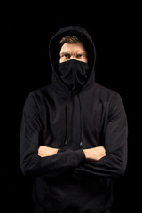 faceless man with open eyes in hoodie standing isolated on black