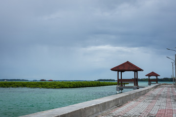 Brick road with two gazebos that facing beautiful ocean with some green healthy mangrove at Harapan Island, Indonesia