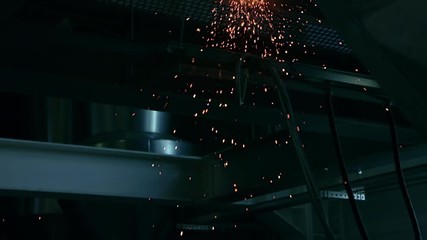 Interior or factory. Construction of production building. Grinding on an industrial plant or factory. Glitter particles in slow motion. The angular grinding machine is cutting the pipe.