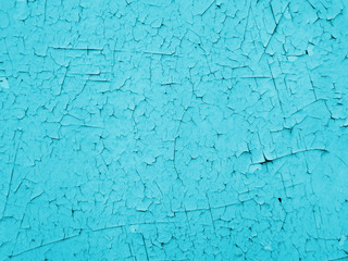 Flaked blue cyan shades paint remains with long cracks scars
