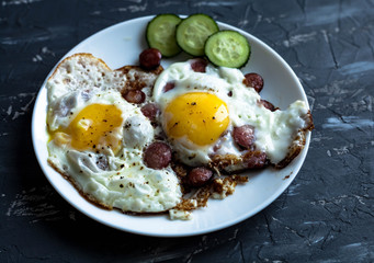 plate of fried eggs with vegetables on a dark background