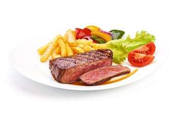 Roasted barbecue medium rare beef steak with french fries and vegetables, fried meat, close-up. isolated on white background