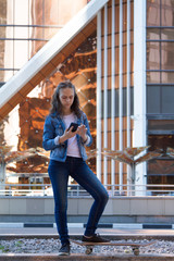 teen girl look at a smartphone in a large metropolis