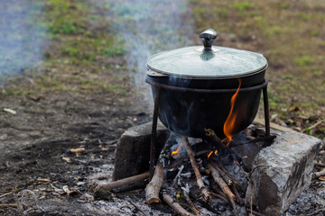 cooking in nature, the soup in the pot is cooked on the fire