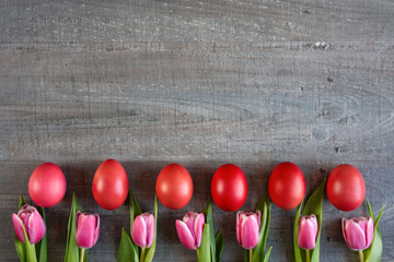 Czerwone pisanki, różowe tulipany, szare tło, wielkanoc