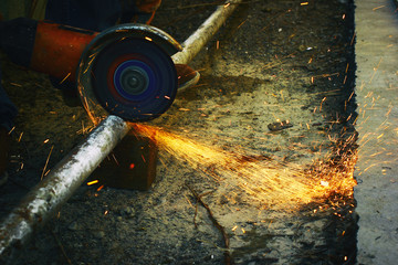 A angular grinding machine cutting a metal tube with a spurks bunch