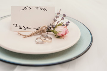 Silwerware. New Year dinner. Luxury dishes on the white table cloth with a card and a flowers on it