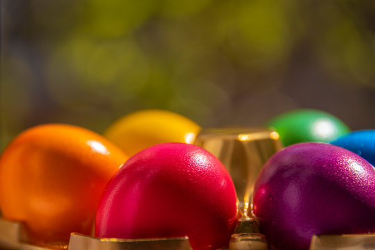 Colorful Easter eggs in basket on soft, plain background