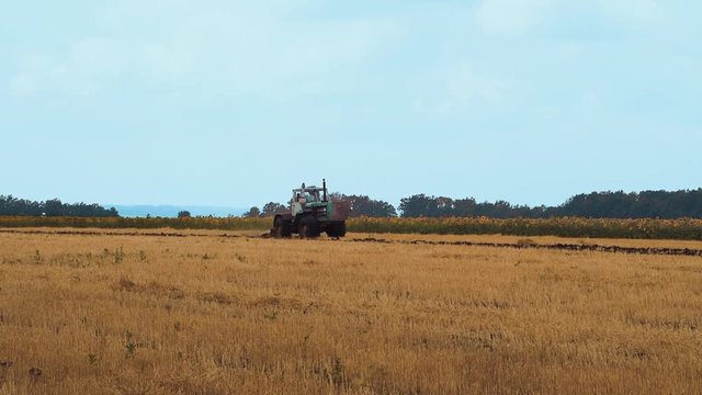 A farmer on a tractor handles the field The farmer on the tractor handles field farm is hard work on the ground