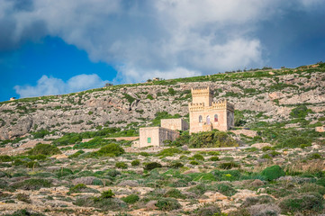 Fototapeta na wymiar Ghar Lapsi tower on a hilly landscape in Malta. Medieval watchtower