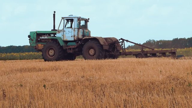 A farmer on a tractor handles the field The farmer on the tractor handles field farm is hard work on the ground