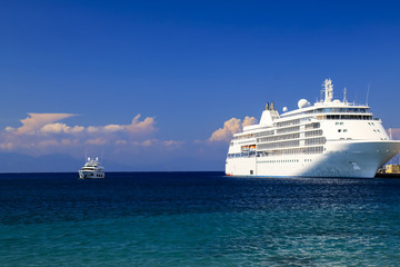 Fototapeta na wymiar Seascape. A large white cruise ship stands in the tourist sea port at sunset, Rhodes, Greece. Travel, recreation and vacation. Liner on the ocean