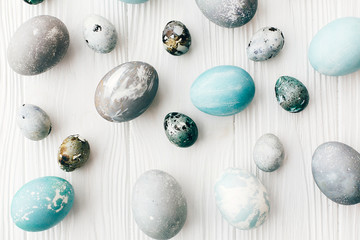 Stylish Easter eggs flat lay on white wooden background. Modern easter eggs painted with natural dye in blue and grey marble. Happy Easter, greeting card image