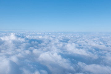 Fototapeta na wymiar Blue White clouds over blue sky background aerial view from a airplane flying above the clouds.