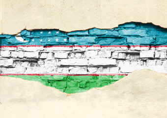 National flag of Uzbekistan on a brick background. Brick wall with partially destroyed plaster, background or texture.