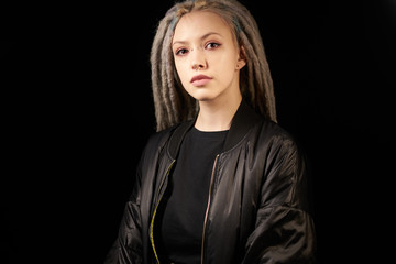 beautiful girl in a black jacket stylish on a black background on black background