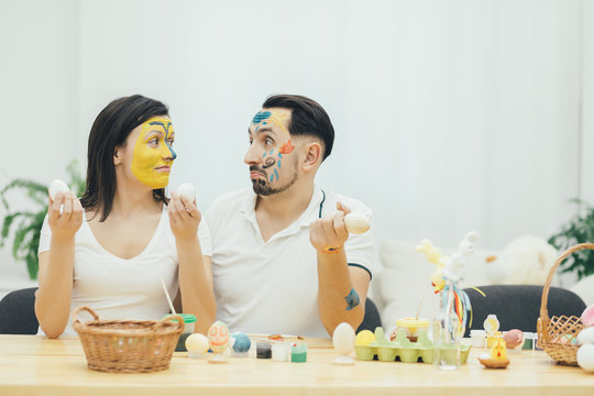 Mother and father painted their faces instead of easter eggs. Foolish behavior. Unforgiveble emotions. Paint and color.