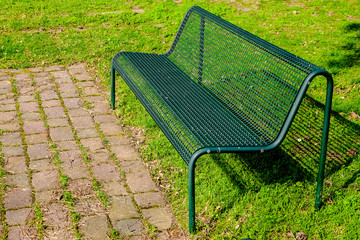 empty green bench on a meadow in the park