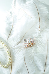 Pearl necklace on white feather
