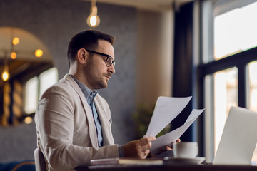 Businessman reading documents while working at casual office.