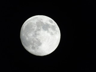 Genova, Italy - 03/20/2019: An amazing photography of the full moon over the city of Genova by night with a great clear sky in background and some stars