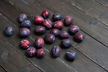 plums on black wooden table