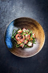 Traditional French octopus braised cooked with Salicornia, lemon curd and spice as top view in a...