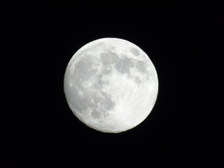 Genova, Italy - 03/20/2019: An amazing photography of the full moon over the city of Genova by night with a great clear sky in background and some stars