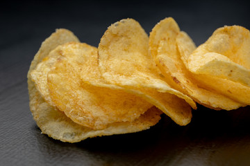 Tasty crisps on the kitchen table. Salty snacks as an addition to beer.